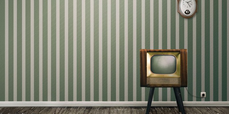 Historia telewizora miała swój początek wiele lat temu. Pierwsze urządzenia wyglądały jak pudła, co widać na zdjęciu salonu w stylu vintage.