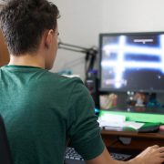 Młody chłopak testuje podczas gry swój nowy komputer gamingowy do 1000 złotych.
