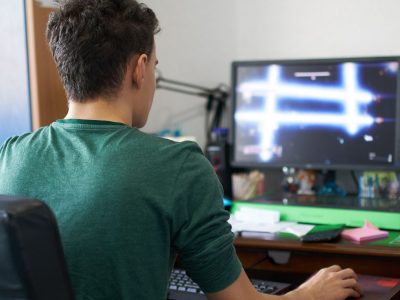 Młody chłopak testuje podczas gry swój nowy komputer gamingowy do 1000 złotych.
