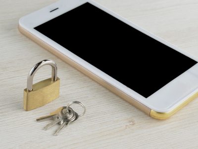 Ochrona telefonu jako koncepcja – obok smartfona leży kłódka i klucze.