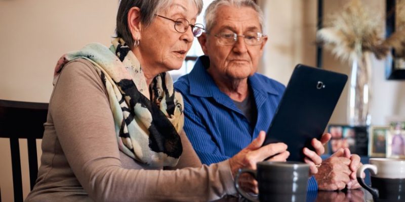 Starsze małżeństwo przed tabletem próbuje sobie poradzić jako seniorzy w Internecie.