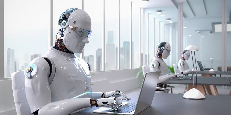 Kogo nie zastąpi sztuczna inteligencja? Na zdjęciu roboty przed laptopami.