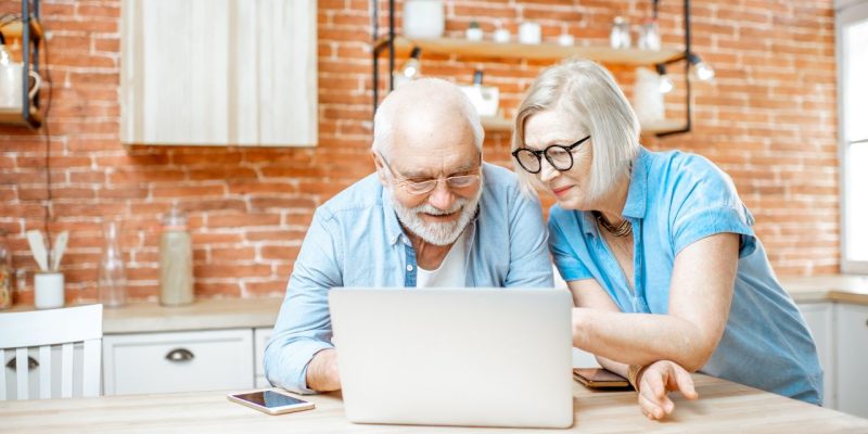 Zwiększanie kompetencji cyfrowych wyzwaniem wśród seniorów. Na zdjęciu starsze małżeństwo przed laptopem.
