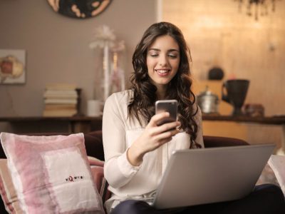Jak zacząć zarabiać pieniądze online? 5 sprawdzonych sposobów. Na zdjęciu kobieta z laptopem i smartfonem.